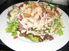料理メニュー写真 イタリア産生ハムと温泉卵のシーザースサラダ カリカリバケットを添え