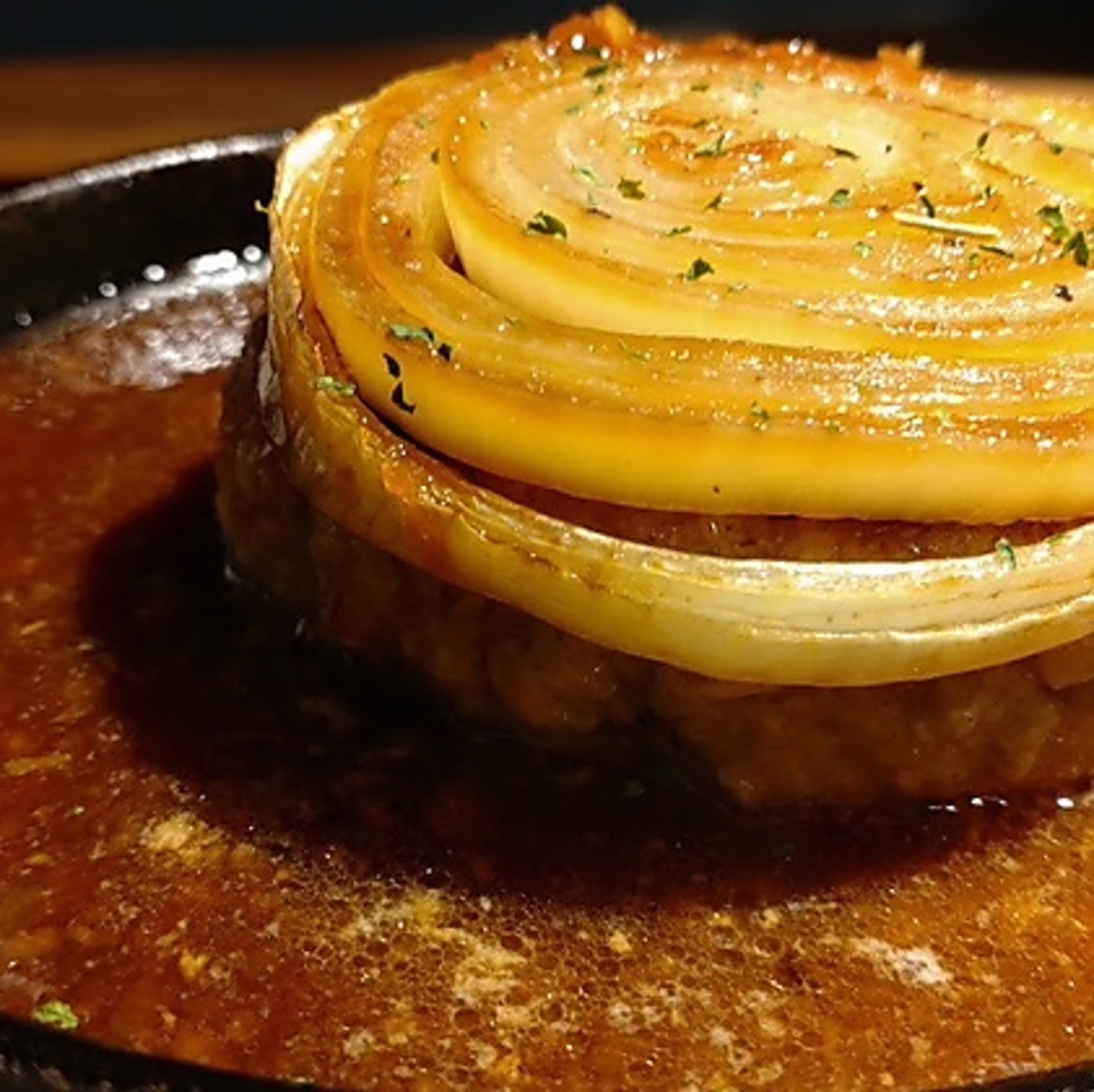 丸ごと焼いた淡路島産玉ねぎを乗せた絶品ハンバーグ。溢れる肉汁と甘みがソースと絡み合う一品です。