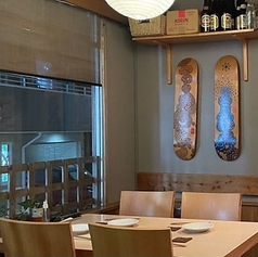 柔らかな照明が優しく照らすテーブル席は、お仕事帰りのサク飲みやご友人との気軽なお食事に最適です。壁には木製のスケートボードのアートが飾られ、和の空間にモダンでお洒落な雰囲気を添えています。ゆったりとお座りいただけるお席で、当店自慢の美味しい和食と厳選された美酒を心ゆくまでお楽しみくださいませ。