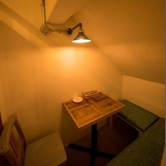 【テーブル席:2名様×1卓】斜めの天井が特徴的な、秘密の隠れ家のような空間。やさしく照らす明かりがゆったりとした雰囲気を演出し、プライベートな時間を過ごせます。デートに◎