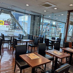 広々とした空間にバランスよく配置されたテーブル席。お一人様での読書から、友人グループでの賑やかなお喋りまで、様々なシーンに柔軟に対応可能です。通路が広く取られているため、ベビーカーをご利用の方も安心してくつろげます。清潔感のある落ち着いた雰囲気の中で、お気に入りの一杯を心ゆくまで味わってください。