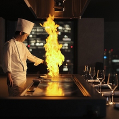 【鉄板カウンター席】鉄板焼きのパフォーマンスを目の前で愉しむことができるライブ感あるカウンター席です。※チャージ1000円/名 ※12歳以下のお子様がいらっしゃる場合は、個室、テーブル席のご案内のみとなりますので予めご了承ください。※系列店舗の写真です