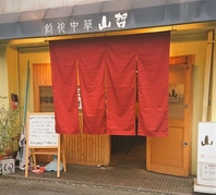 赤い暖簾が目印。お店のイメージカラーです。