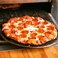 【熱々!!キツネ色】 丁寧にトッピングされたピザを、裏面がこんがりとキツネ色になるまで、熱々のオーブンで一枚一枚焼き上げます。