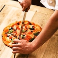 【ナイスカット】 直径30cmのピザを一気に切れる大きな包丁で、勢い良く切り分けます。これも大きなまな板（ピール）の上を滑らせ、お皿にナイスイン!