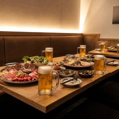 宴会セッティングのソファ席。肉の大皿とビールで乾杯をどうぞ。