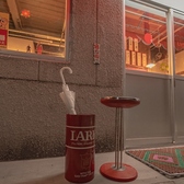 まるで誰かの忘れ物のように傘が置かれ、周囲の温かい光がほっとする雰囲気を醸し出しています。窓越しには手書きのメニューや独特な装飾が見え、訪れる人々の笑い声や会話が聞こえてきそうです。日常の中にある小さな幸せや、心温まる瞬間を感じることができると思います。昭和レトロな雰囲気をぜひ楽しんでください。