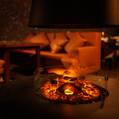 焚火のおぼろげな灯りが店内を静かに照らし、都会の喧騒を忘れさせてくれます。間接照明により心地よい明かりに包まれる空間は、日常を忘れてリラックスしたい夜に最適です。特に人気のソファ席は、ゆったりと寛げるため予約必須。揺らめく火を眺めながら、シェフ渾身の料理とともに至福の時間をどうぞ。