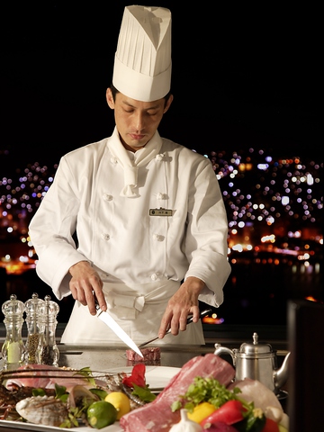 目の前で調理をするシェフの巧みな技と、贅沢な夜景を堪能しながら食事ができる。