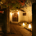 石堀の門をくぐり、季節の情景に囲まれた入り口。足元を優しい灯りが包み込みゲストをお迎えします。