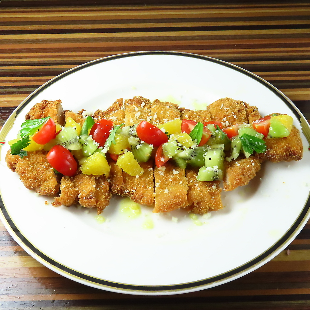 ミラノ風カツレツ…大判に叩いた国産牛豚ロースをサクッと！トマトとフルーツのソース