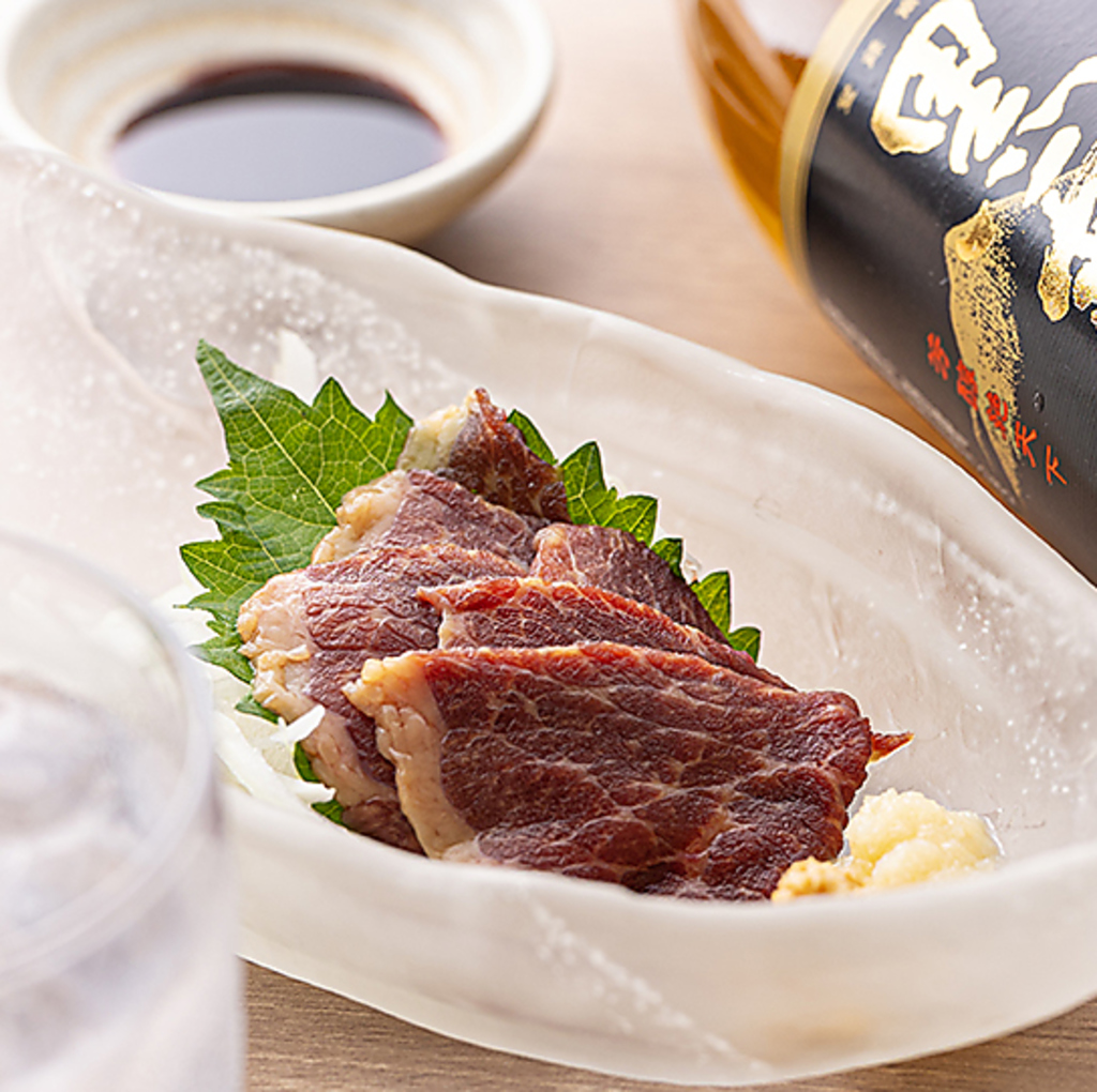 鮮度抜群！とろける旨みの新鮮馬刺し。特製の甘口醤油と薬味で味わう、お酒が進む逸品です。