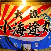 壁に飾られた大きな大漁旗。海鮮居酒屋らしい雰囲気。