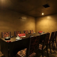 【テーブル席：4～12名様】コンクリート打ちっぱなしの壁がモダンでスタイリッシュな雰囲気を演出する、静かな半個室です。温かな間接照明に包まれた空間は、周囲を気にせずゆったりと語らえる大人の隠れ家。記念日のディナーや歓送迎会など、特別なプライベートシーンでもご利用いただけます◎