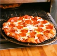 【熱々!!キツネ色】 丁寧にトッピングされたピザを、裏面がこんがりとキツネ色になるまで、熱々のオーブンで一枚一枚焼き上げます。