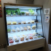 全ての具材が透明な容器に種類別に分けられ、冷蔵されたショーケース内に陳列されています。具材名が明確に表示されており、お客様に安心して選んでいただけるよう、衛生管理と見やすさに配慮しています。