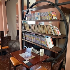 2階席は漫画や絵本も充実しており、家族連れに最適。広めのテーブルで快適にお過ごしいただけます。