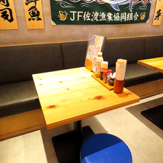 サク飲みにも最適なテーブル席。大漁旗の元で提供する自慢の鮮魚料理。海を感じて更に美味しく召し上がれること間違いなし！