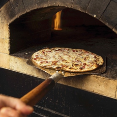 窯で焼き上げるフランス・アルザス地方のピザ『タルトフランベ 』の写真