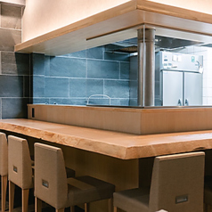 【1階 カウンター席】1階は大きなL字型カウンター席を中心に、落ち着いた雰囲気が広がっています。厨房との距離も近いので、お酒について二代目との会話を楽しむことができます。カジュアルな接待や、ディナーデート、一人飲みなど様々なシーンでご利用下さい。