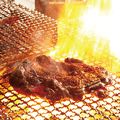 料理メニュー写真 豪快に焼き上げる宮崎の郷土料理「親鶏もも炭火焼」は、岐阜県関市上之保の青柚子椒と一緒に