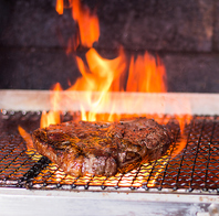 薪火グリラーで焼き上げる肉料理