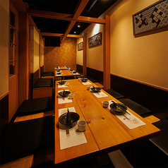 ［14～18名様］上質な木の温もりが息づく和の個室空間。天井の梁や障子風の扉が和の伝統美を演出しながらも、現代的な居心地の良さも兼ね備え、特別なひとときをゆったりとお過ごし頂ける空間です。