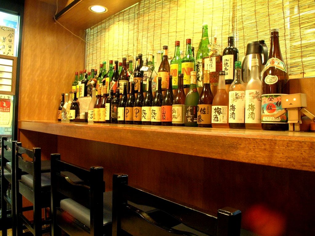 入ってすぐのカウンターには焼酎のボトルがズラリと並びます。