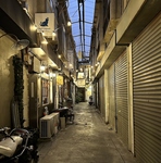繊維街の趣のある通りを歩けばお店へ上がる2階踊り場部分に目印となる凹凸Tacosの看板がございます。