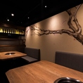 壁面に手描きの桜が描かれたベンチシートタイプの半個室テーブル席。