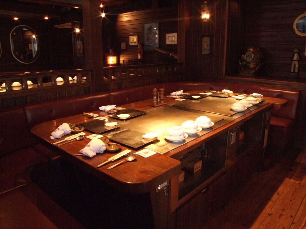 輝く鉄板とシックな色合いの内装の対比が美しい店内