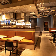 オープンキッチンに面した広々としたテーブル席は、当店の活気を感じながらお食事を楽しみたい方に最適です。温かみのあるオレンジ色のベンチシートと、モダンなテーブルが配置され、ゆったりとくつろげる空間を提供します。気の合う仲間との賑やかな女子会はもちろん、デートやご家族でのご利用にもぴったり。