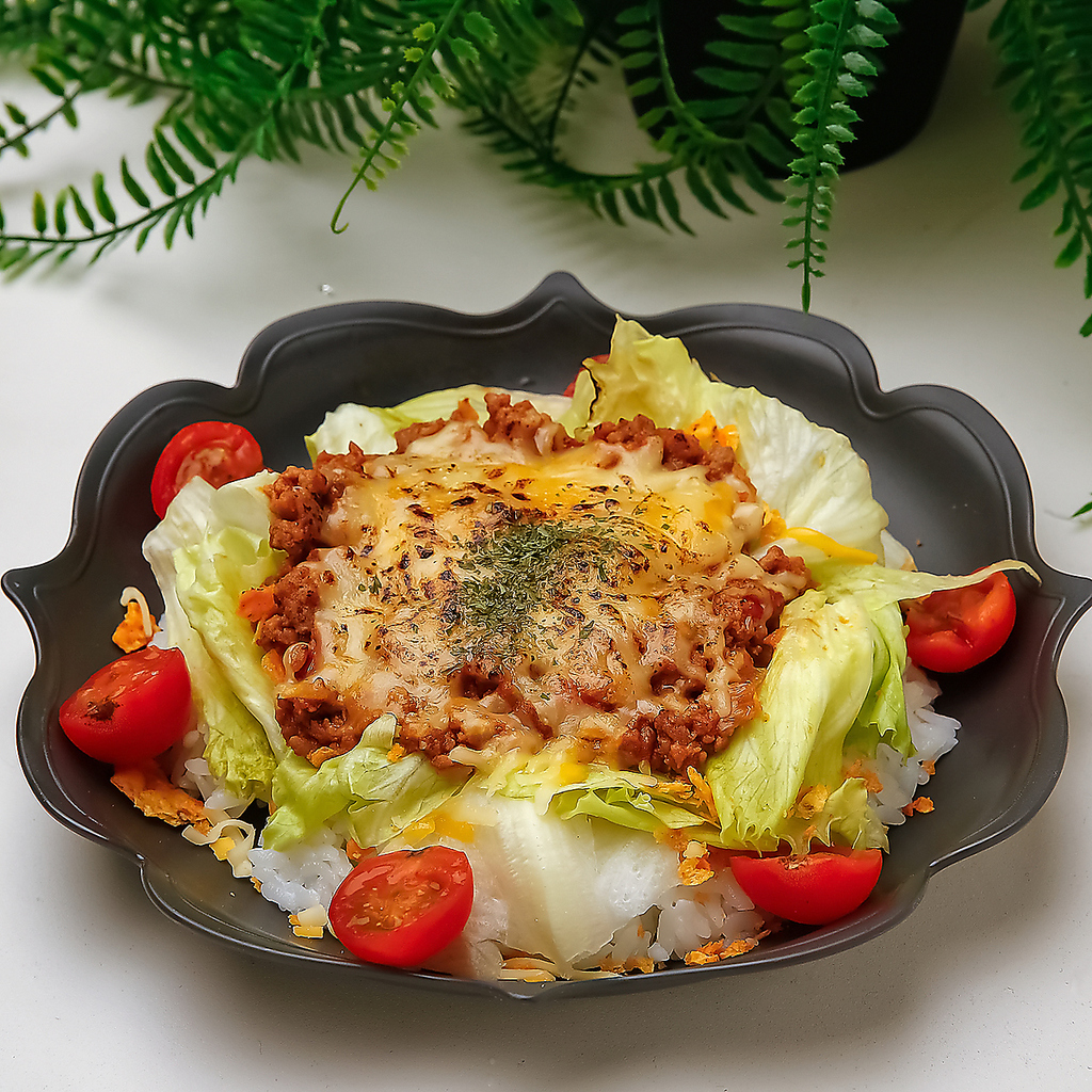 スパイシーなタコライスは、ひき肉たっぷりで新鮮な野菜とチーズと絡む、カラフルで満足感のある一品