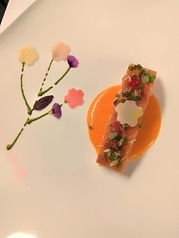 北海道産桜マス、赤パプリカとルビーグレープフルーツソース、根菜のピクルスの写真