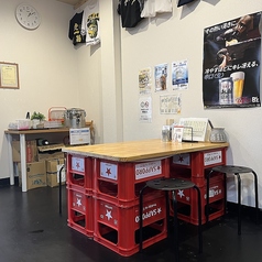 店内にひとつだけの4名掛けテーブル席。ビールケースをベースにしたテーブルは、素朴で親しみやすい雰囲気が魅力。まるで昔懐かしい縁側のような温もりがあり、友人同士のちょい飲みやご家族との食事にぴったりです。