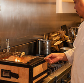 炭火焼きの料理を目の前で焼く様子は、まさにライブ感満載。目で、耳で、そして香りで料理の魅力を感じながら、特別なひとときをお過ごしください。
