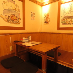 2～4席の座敷席は、足を伸ばしてゆったりくつろげる居心地の良い空間です。木の温もりが感じられるデザインで、壁にはレトロなポスターや温かみのあるイラストが飾られ、落ち着いた雰囲気を演出。仲間との飲み会やゆっくり語り合いたいシーンにぴったりな、リラックスできる和の空間です。
