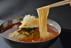 【当店の看板メニュー冷麺】スープによく絡む、自家製の手打ち麺を使用。お食事や宴会の〆に人気の一品！の写真