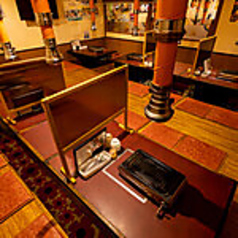 広々とした2階席は、学生グループや会社の同僚との飲み会など、中規模な利用シーンに最適。壁側にはメニューが貼られ、料理選びもスムーズ。