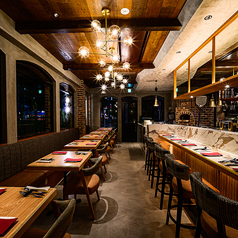 1Fのテーブル席は、木の温もりを感じる落ち着いた雰囲気。薪窯ピッツァや鮮魚イタリアンを囲みながら、ワイン片手に会話も弾む空間です。友人との飲み会や普段使いにもおすすめ。