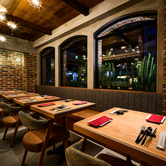 1Fのテーブル席は、気取らず過ごせるカジュアルな雰囲気。薪窯ピッツァやパスタをシェアしながら、ワイワイ盛り上がれるのが魅力です。友人同士の飲み会やちょっとした集まりにもぴったりの空間です。