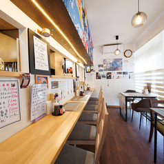 2名様掛けのテーブル席は、カップルやご夫婦、友人との語らいにぴったりの空間です。木目を基調とした明るく清潔感のある店内で、隣り合って食事を楽しめます。