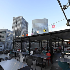 「テントが開くと広がる夜空、特別な屋上テーブル席」ライトアップされた屋上で、ビル群の中提灯の光の中で食事を楽しめます。開閉式テントで開いたテントの向こうに広がる夜空の下安心・快適に過ごせるのも嬉しいポイント。梅田/大阪駅/駅ビル/BBQ/焼肉/貸切/歓送迎会/屋上/宴会/ビアガーデン/テラス