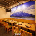 ［10～12名様］壁一面に描かれた壮麗な富士山のアートが目を引くテーブル席。木目のテーブルや椅子が照明と調和し、心落ち着くひとときを演出。器にもこだわりが見られ、料理を待つ時間まで愉しめます。