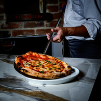 石窯で焼き上げる焼き立てピッツァ