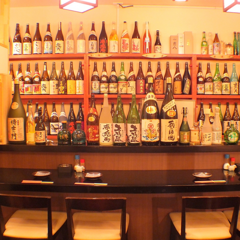 カウンターの前に広がる、焼酎&日本酒ボトルは圧巻！常時、約300種ほど取り揃えております。