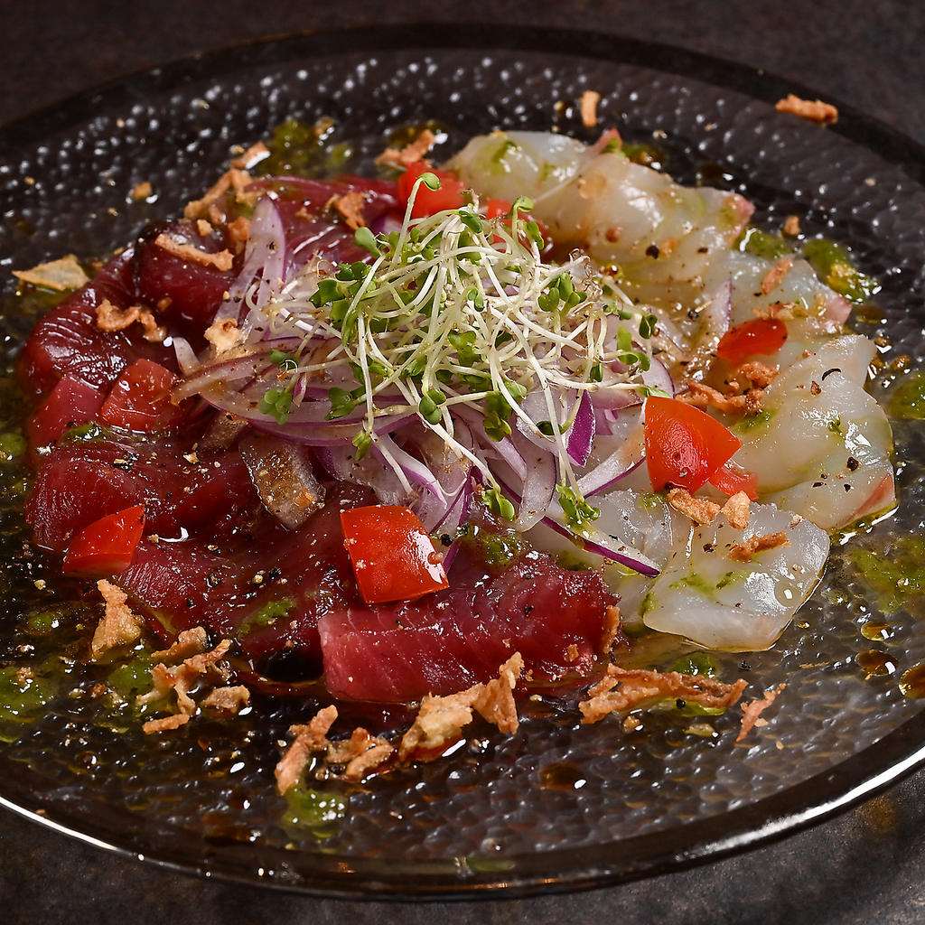 鮮度抜群の魚介と彩り野菜を贅沢に盛り合わせた一皿。まず頼まれる鉄板の名物サラダ＆カルパッチョ。