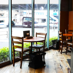ガラス窓から明るい陽光が差し込む2名テーブル席