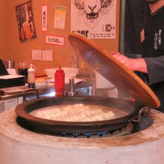 店内中央の【特大鉄なべ】で豪快に焼き上げる究極の餃子