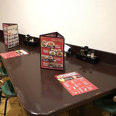 清潔感のあるシンプルなデザインの四人掛けテーブル席。座面が柔らかなクッションなので、快適な座り心地になっております♪全体的に温かみのある雰囲気を醸し出している店内は、友人や家族とともにリラックスした時間を過ごすのにぴったりな場所。家族の集まりや、買い物帰り、飲み会など、多様なシーンにお使いください！